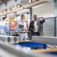 Businessman talking to businesswoman in factory
