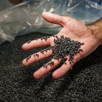 Close up photo of male hand holding plastic polymer granules