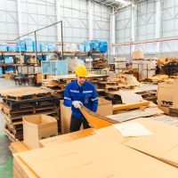 paper cardboard manufacture factory concept, industry worker person working with machine to recycling material package box in warehouse storage or plant production for global logistic business